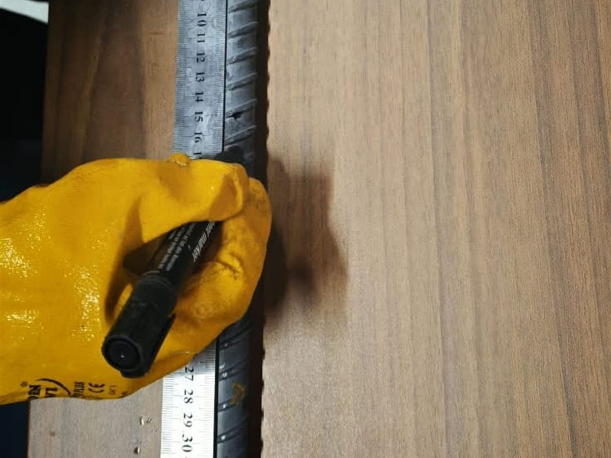 Eldivenli el cetvelle inşaat demirine işaret koyuyor