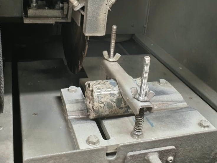 Kesme makinesinin tablasında sabitlenmiş beton karot
